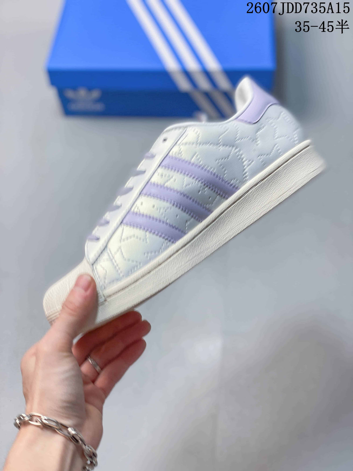Side profile showing the white upper, lavender three stripes, lace-up design, and rubber sole.