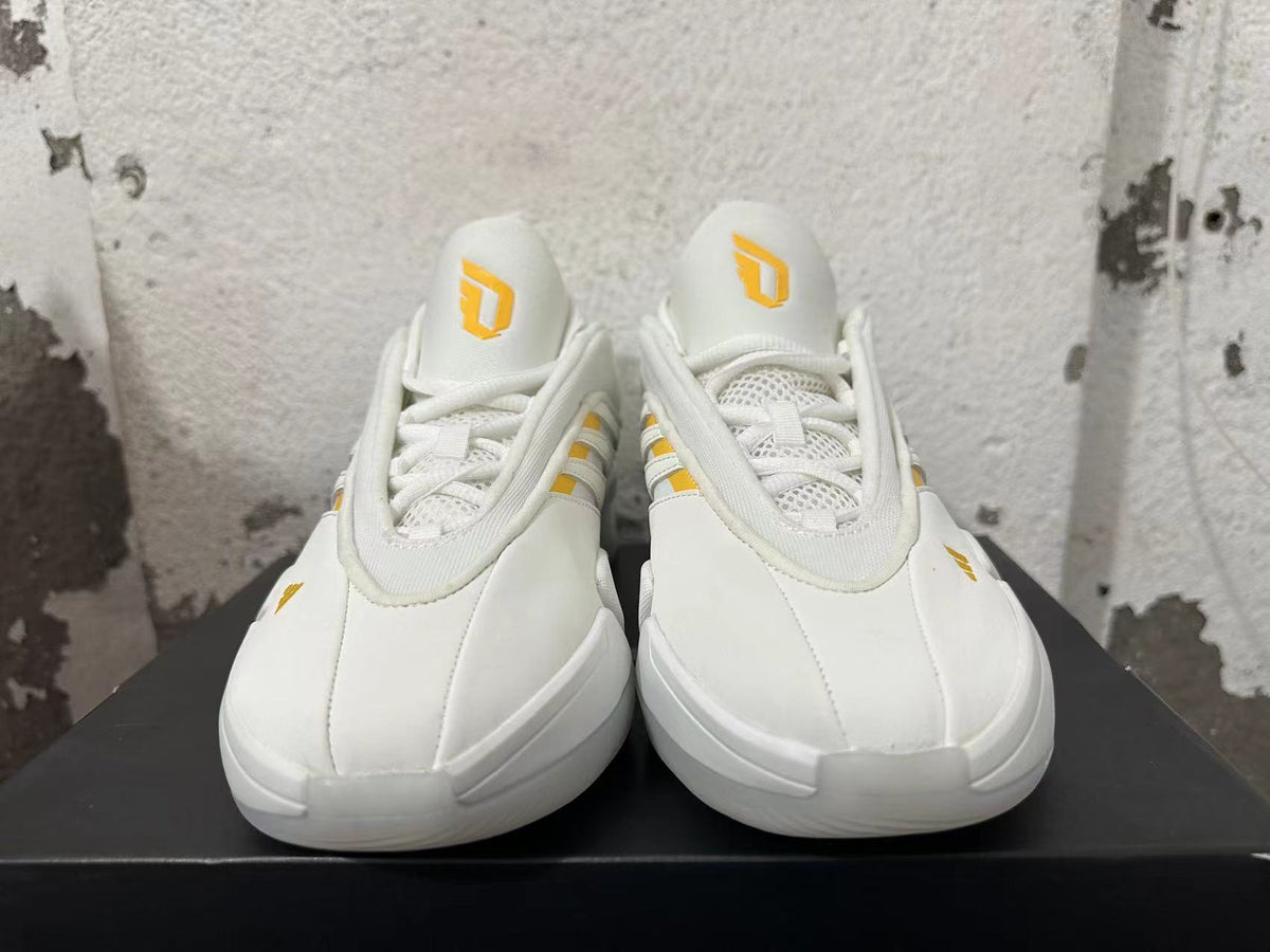 Front view of white Adidas Dame 9 basketball shoes with yellow tongue logos