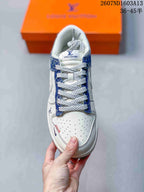 Top view showing the white perforated toe box, blue patterned eyestay, white laces, and tongue label.