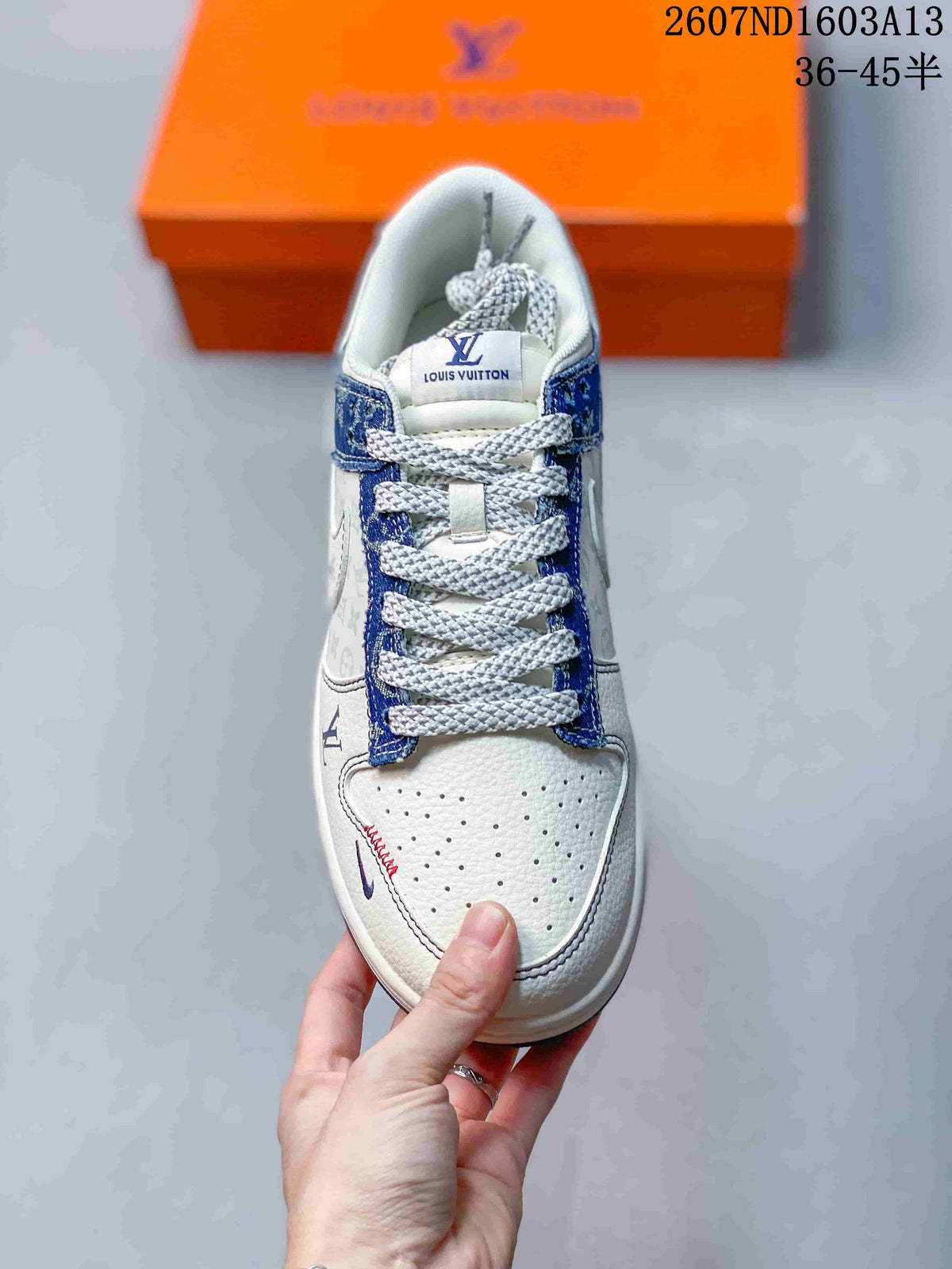 Top view showing the white perforated toe box, blue patterned eyestay, white laces, and tongue label.