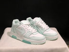 Three-quarter front view of the white low-top sneaker pair with perforated toe panels, flat laces and pale mint outsole accents.