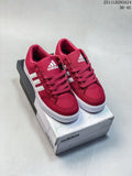 Pair of red adidas low-top sneakers with white stripes displayed on an adidas shoe box.