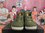 Front view of olive green Jordan high-top sneakers with orange accents and lace-up closure