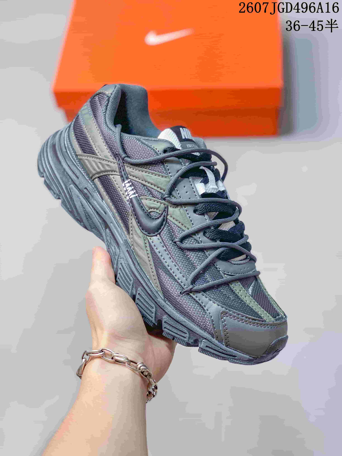 Three-quarter side view of the gray and olive sneaker showing the layered upper and thick outsole.