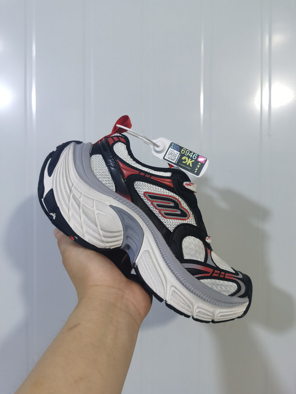 Angled view of the Skechers 1101 sneaker showing the mesh upper, side logo detail, gray midsole accent and black outsole.