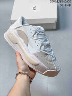 White low-top sneaker with light gray suede-like accent panels.