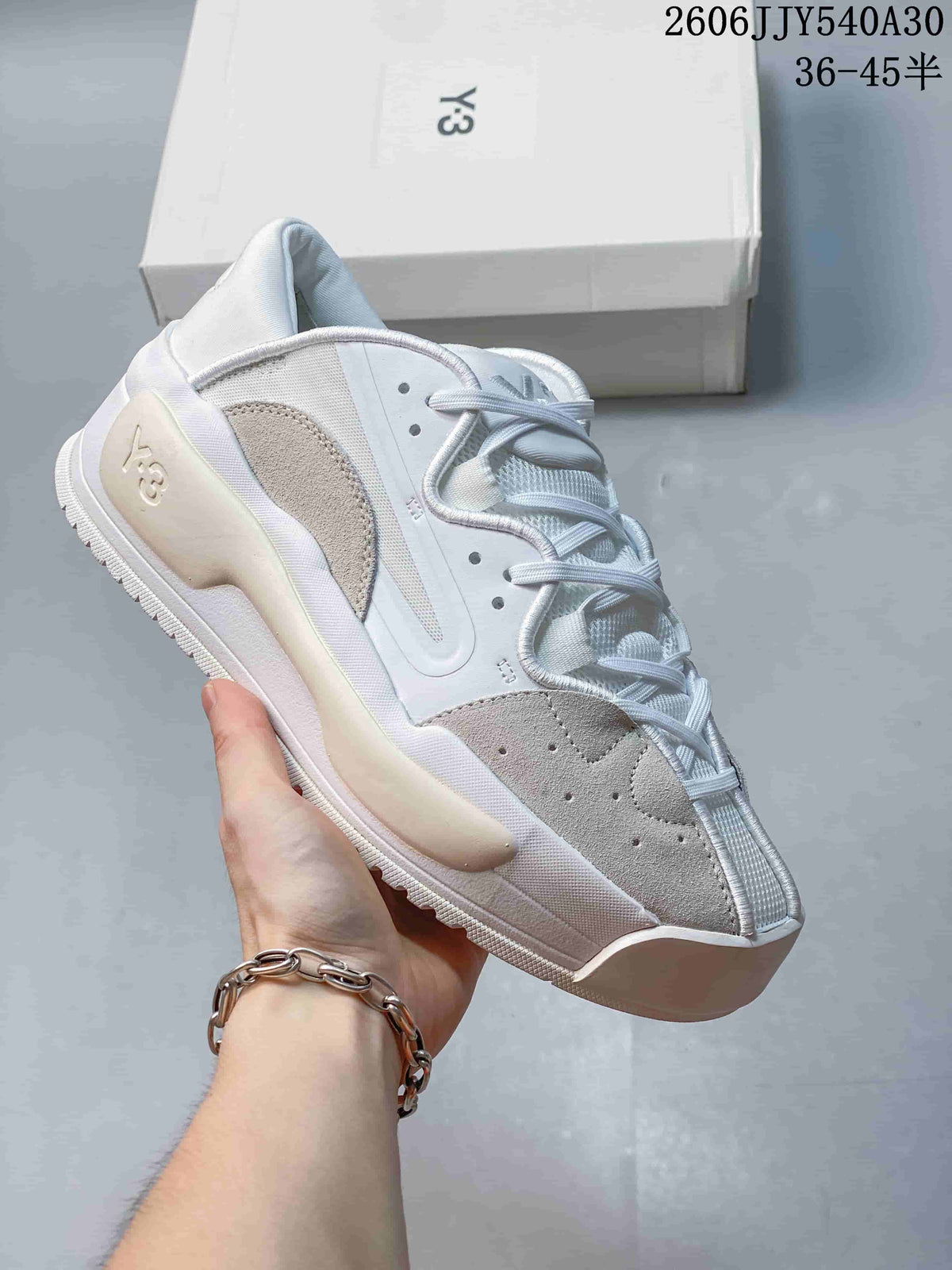 White low-top sneaker with light gray suede-like accent panels.