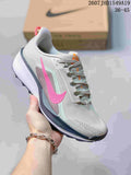 Gray Nike Zoom Fly 5 sneaker with a bright pink Swoosh and mint accents, photographed in front of a shoe box.