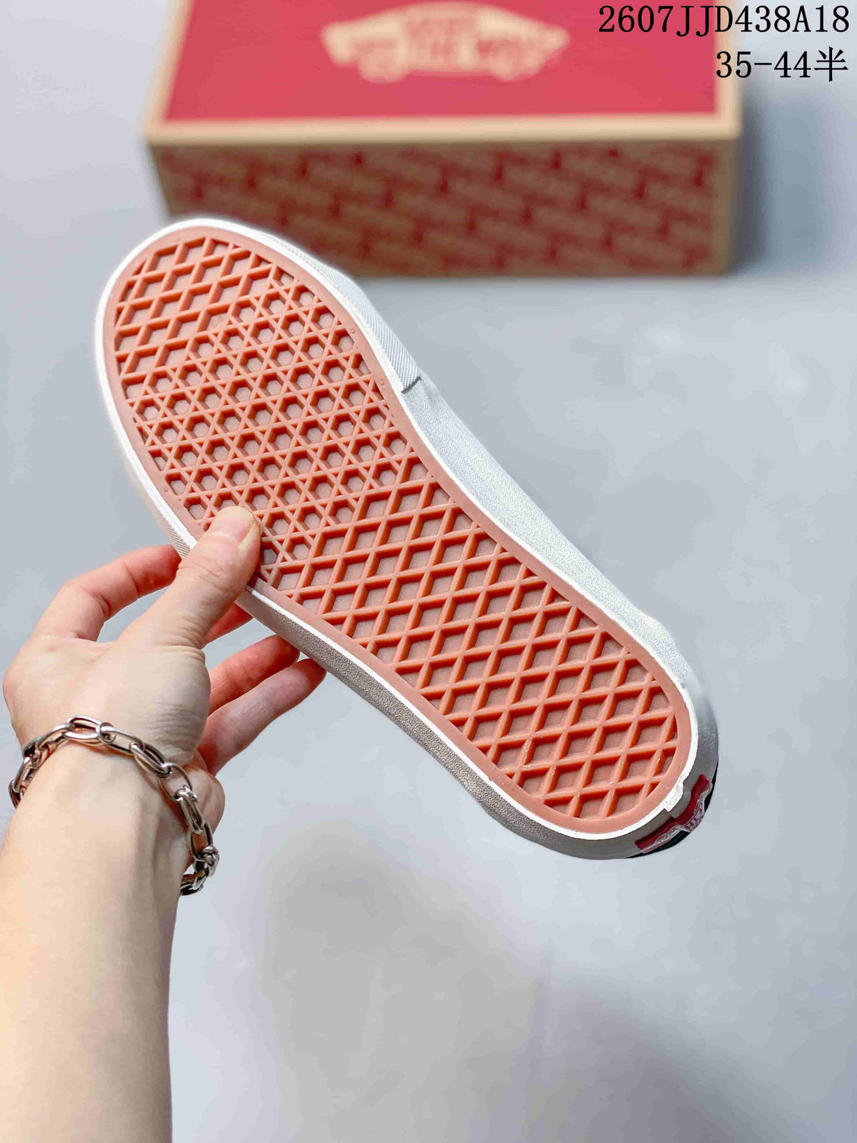 Close view of the sneaker outsole showing a waffle-pattern tread in a contrasting orange tone.