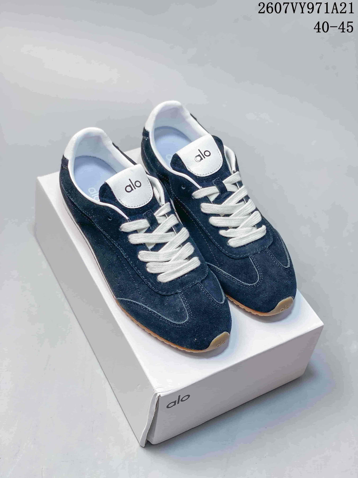 Navy Alo Yoga low-top sneakers with white laces and gum-colored outsoles displayed on a box; source text shows style code 2607VY971A21 and sizes 40–45.