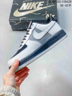 Side view of a low-top sneaker with white and grey panels, a white Swoosh, and a dark midsole.