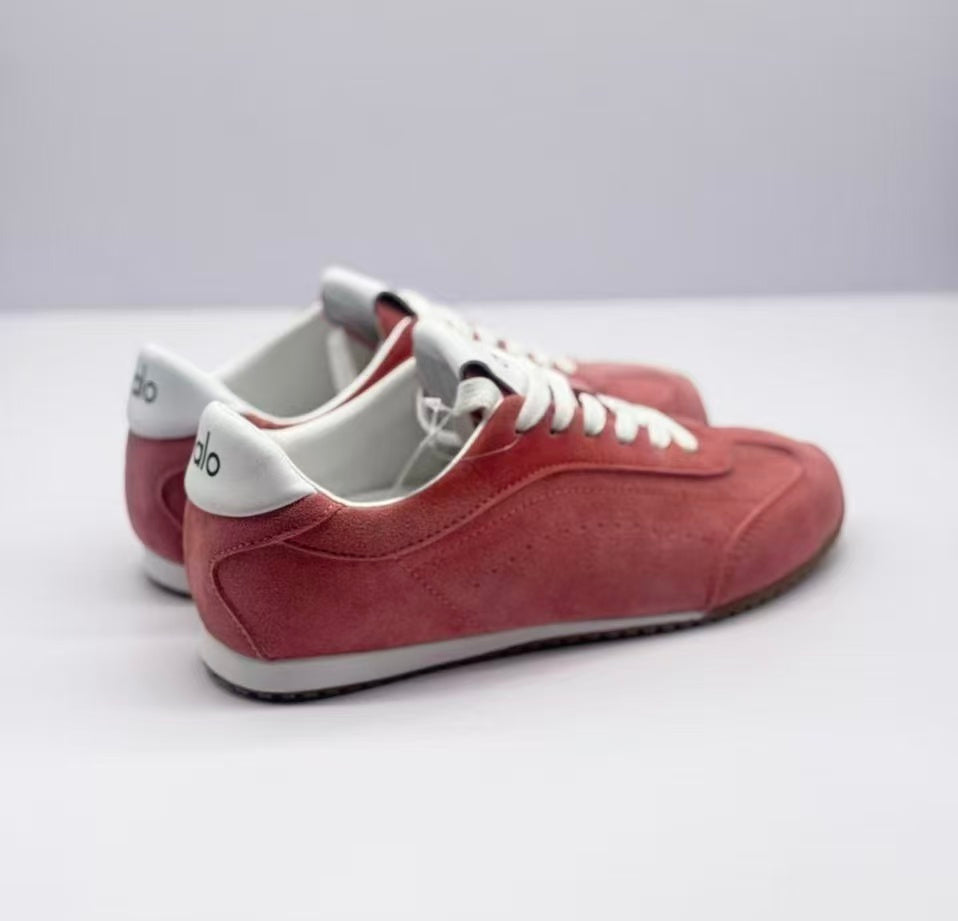 Rear three-quarter view showing the white heel details, pink uppers and layered soles.