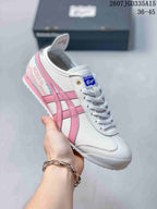 Angled side view showing the white and pink colorway, branded tongue, layered side stripes and Mexico 66 lettering detail.