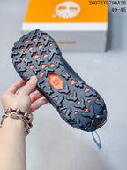 Close view of the rugged outsole with deep directional lugs and an orange Timberland detail.
