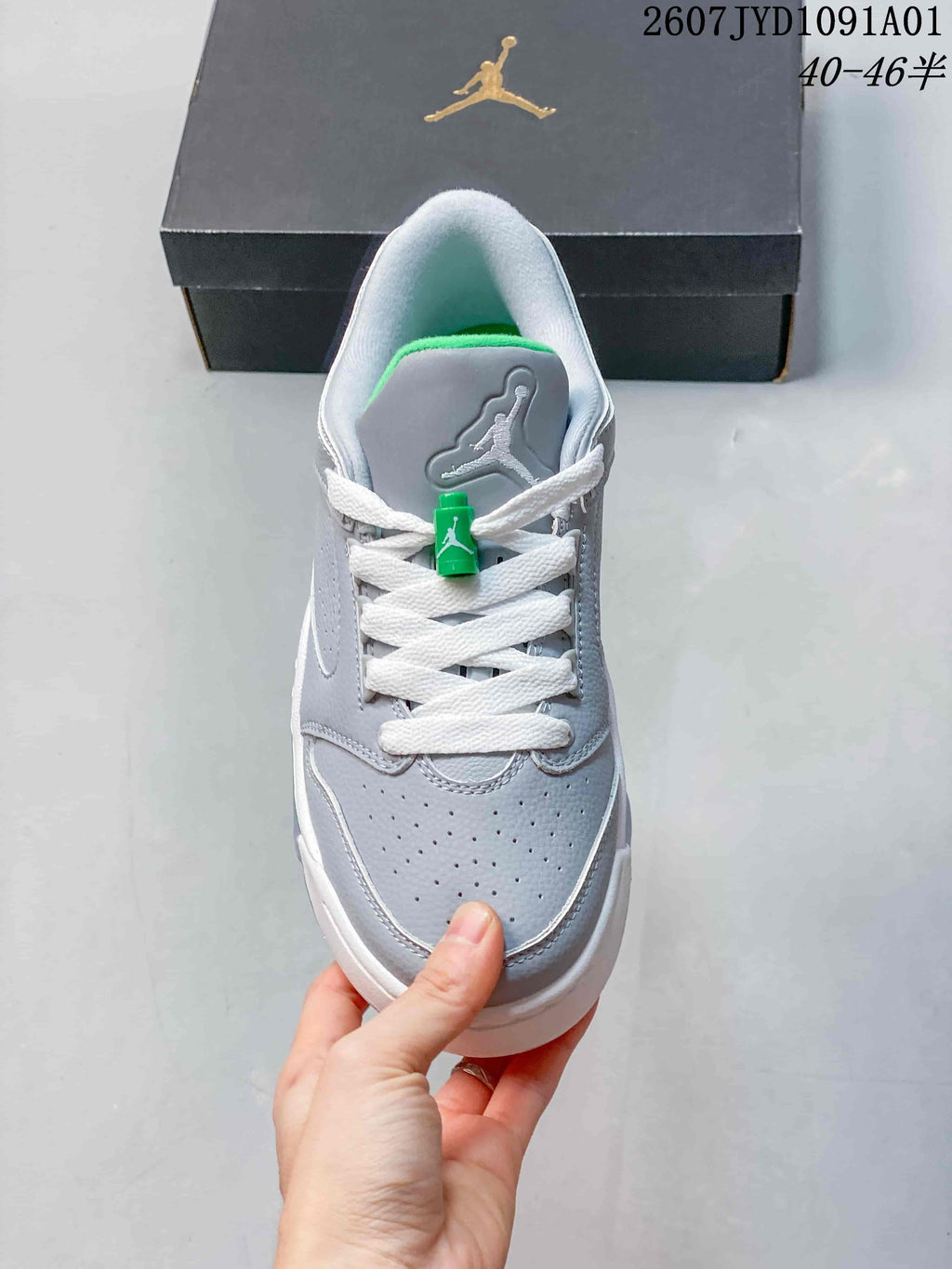 Front view showing perforated toe, white laces, and green lace detail