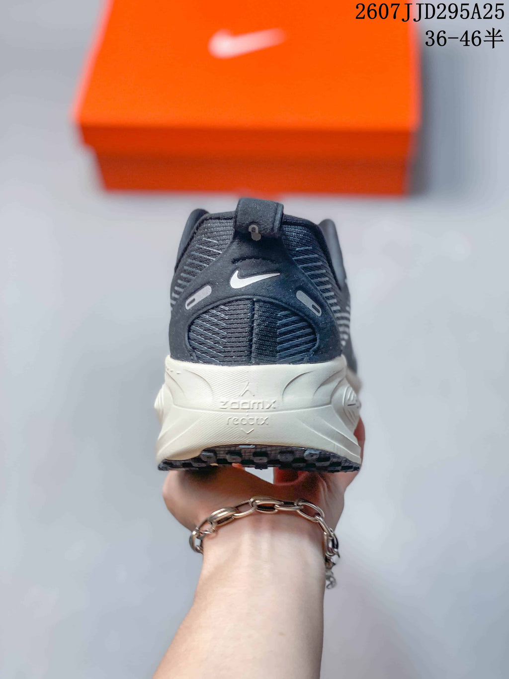 Rear view of the Nike Vomero 18 showing the padded heel, pull tab, dark upper, and midsole markings for ZoomX and ReactX.