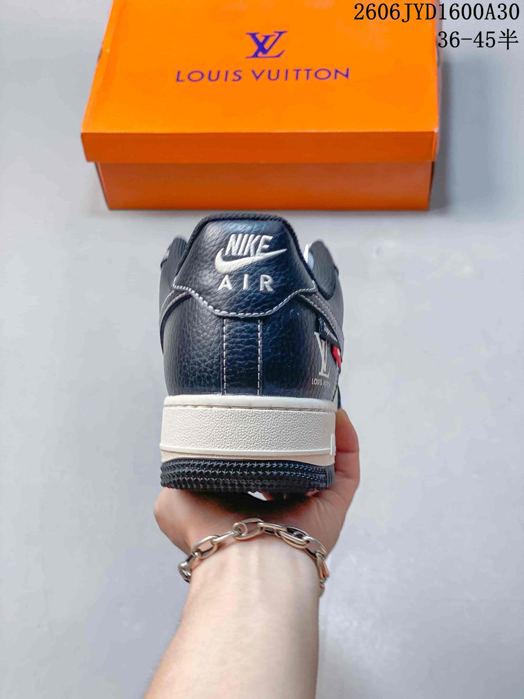 Rear view of a navy sneaker with a white midsole and branded heel tab