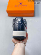 Rear view of a navy sneaker with a white midsole and branded heel tab