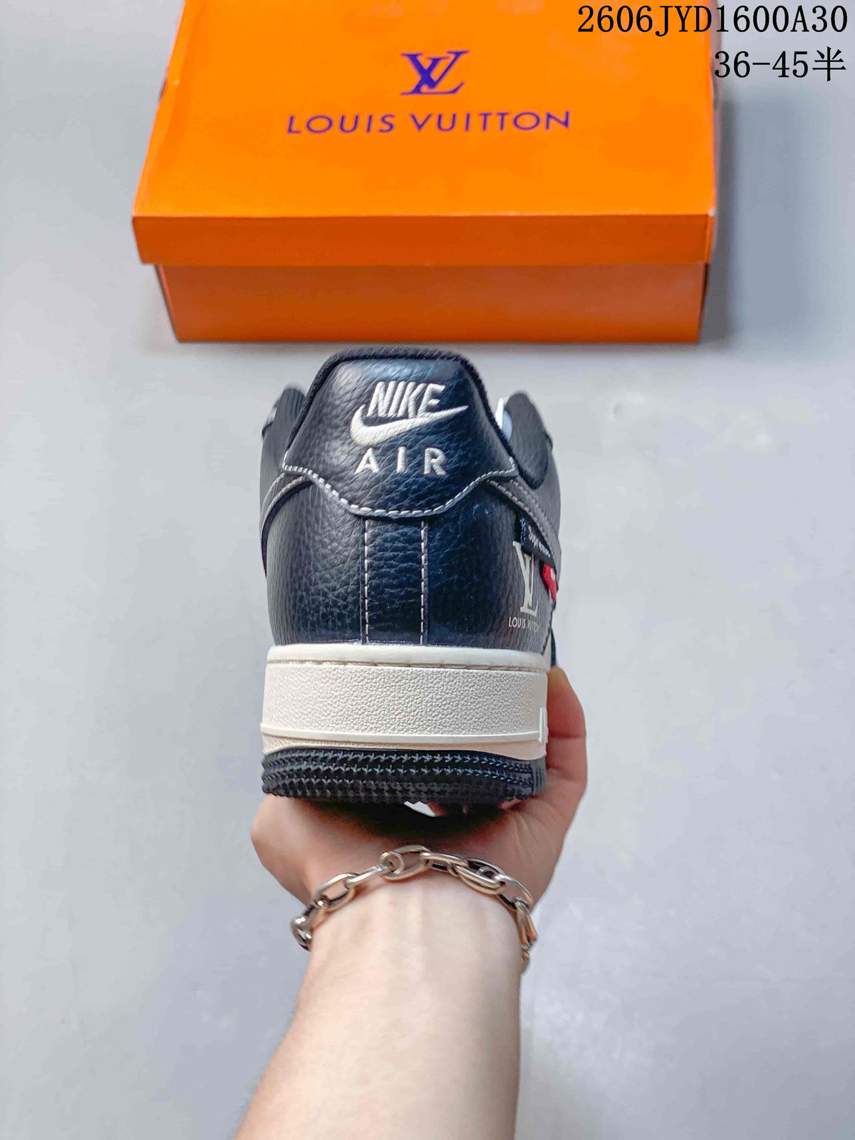 Rear view of a navy sneaker with a white midsole and branded heel tab