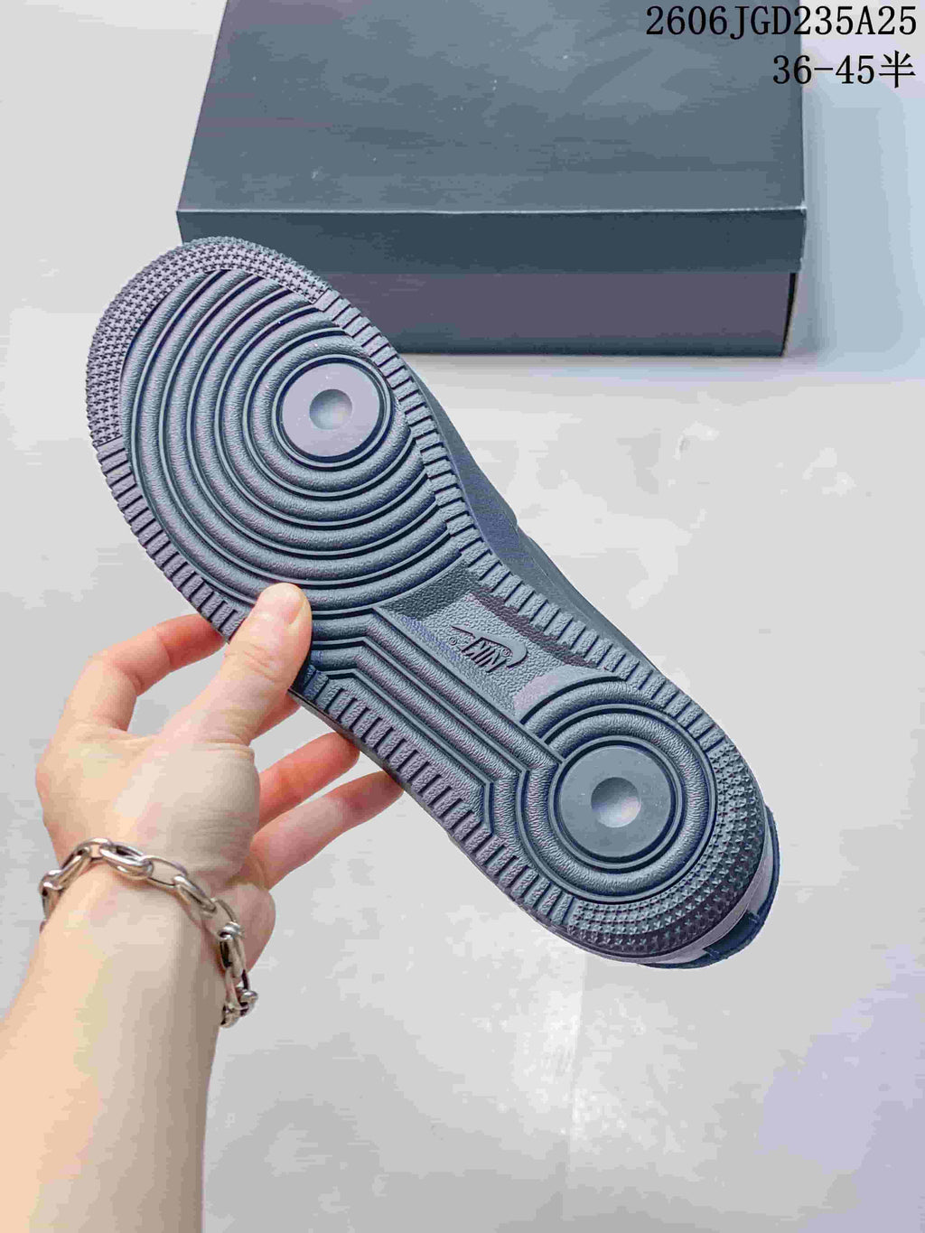 Outsole view showing the circular traction pattern and textured rubber tread of the dark sneaker.