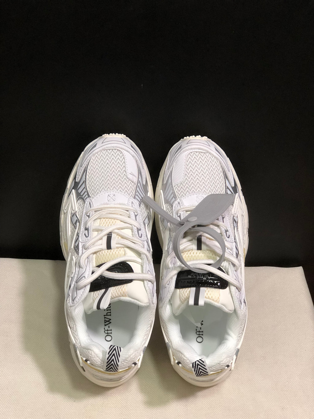 Top view showing the white lace-up construction, mesh-like upper panels, and branded insoles.