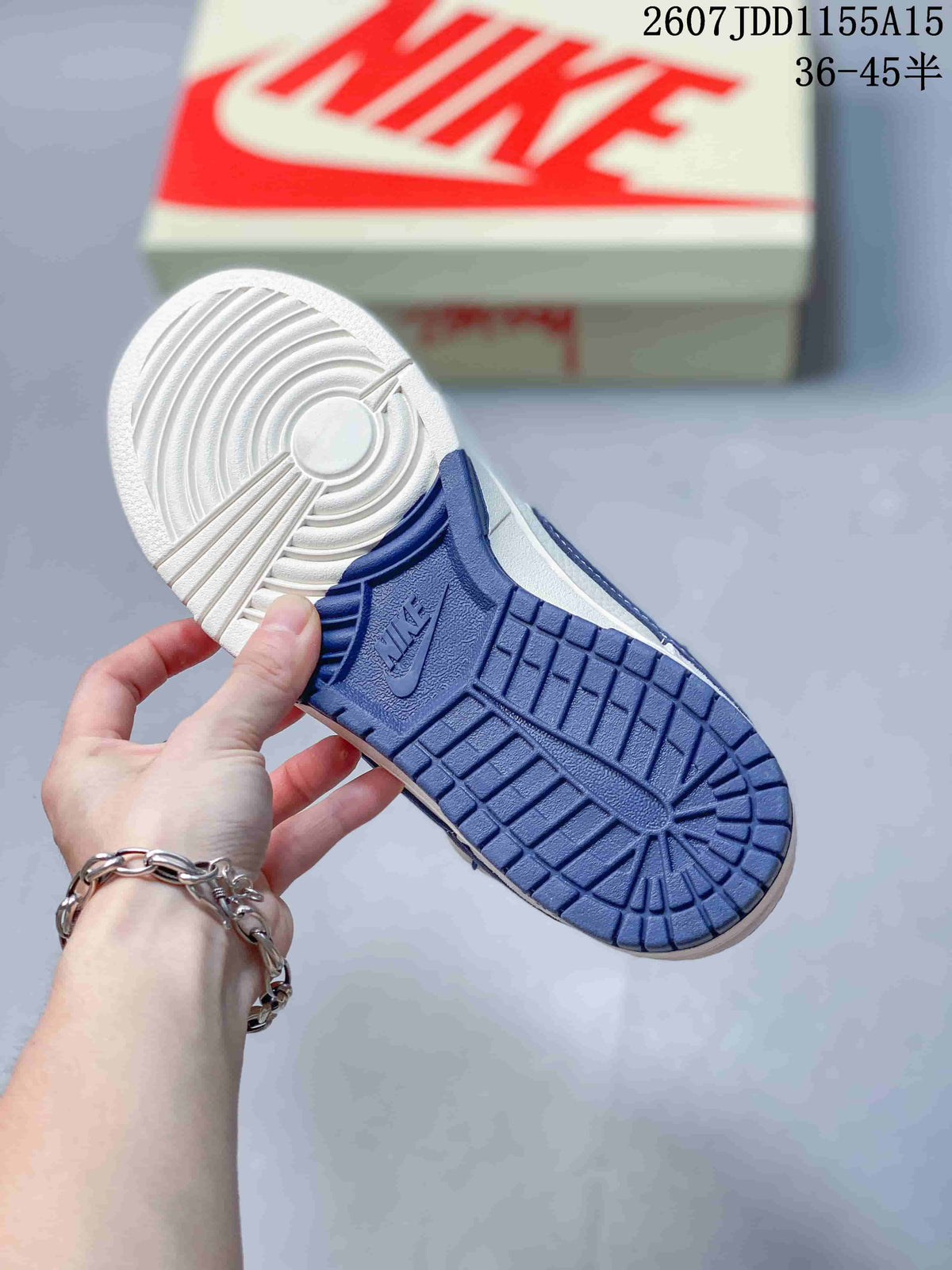 Underside view showing the navy-and-white patterned rubber outsole of the sneaker.