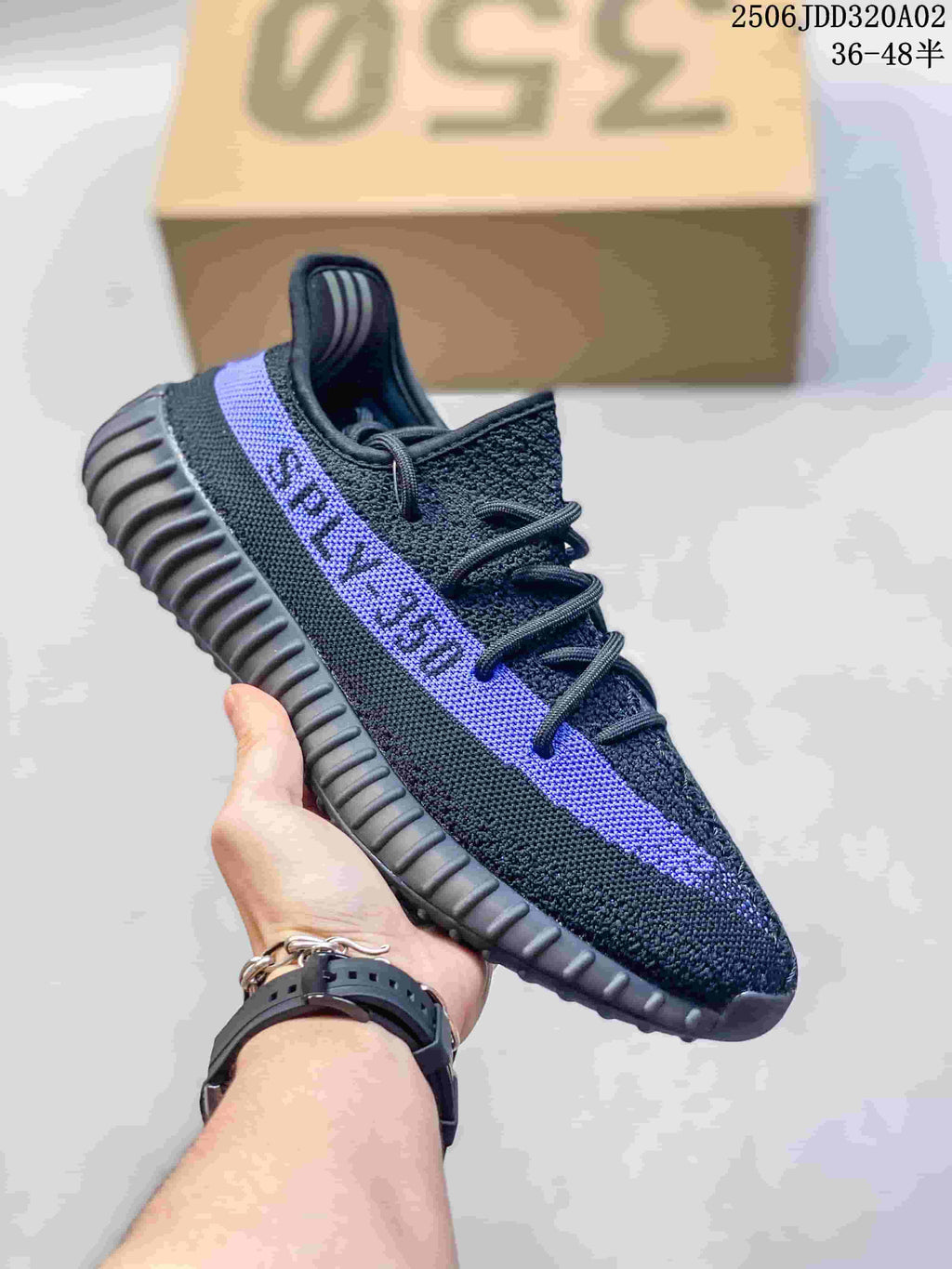 Black knit sneaker with a purple side stripe, black laces, and a ribbed black sole; size range marking is visible on the box.