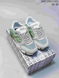 Pair of gray and green Premiata sneakers displayed on a patterned shoebox.