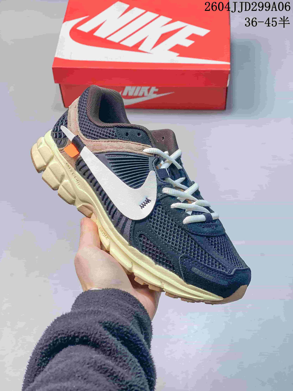 Angled side view of the navy sneaker showing the layered upper, white Swoosh branding, orange accent, and textured outsole.