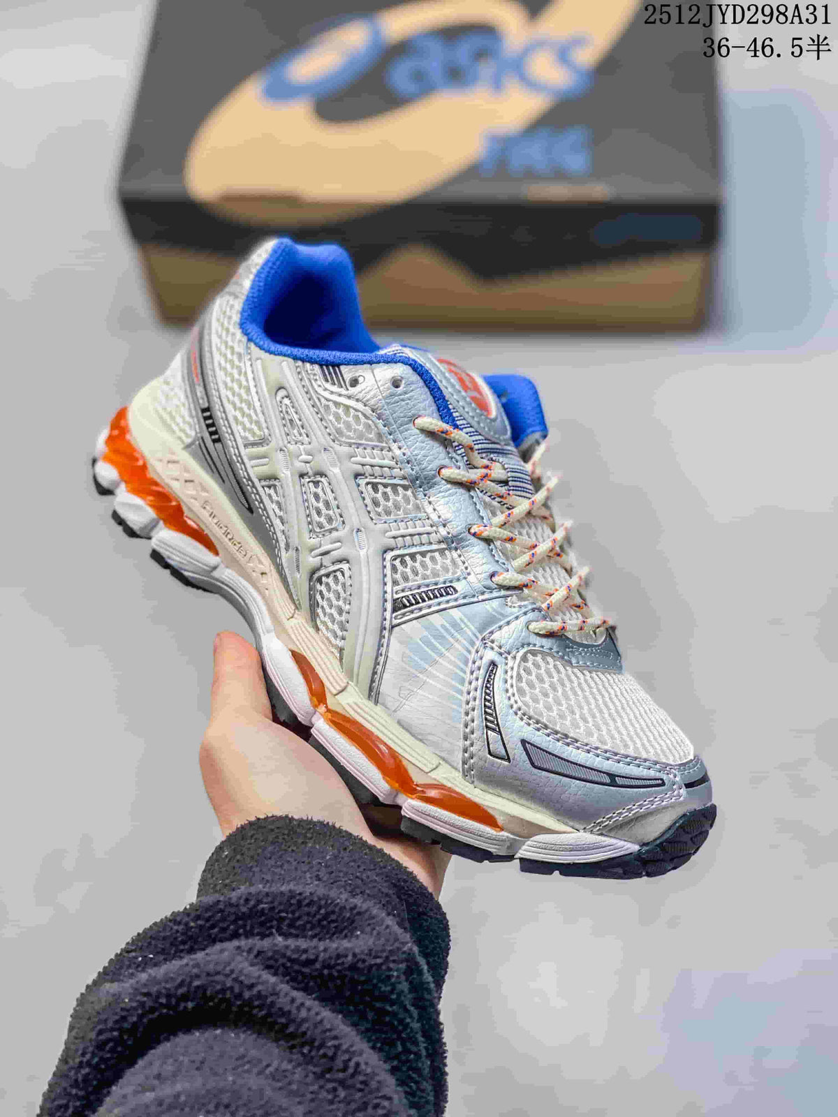 Side view of a silver and white ASICS Gel-Kayano 12.1 shoe with blue and orange details