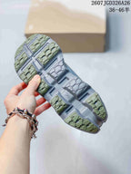 Underside view of the sneaker showing the olive and gray outsole tread pattern and sculpted channels.