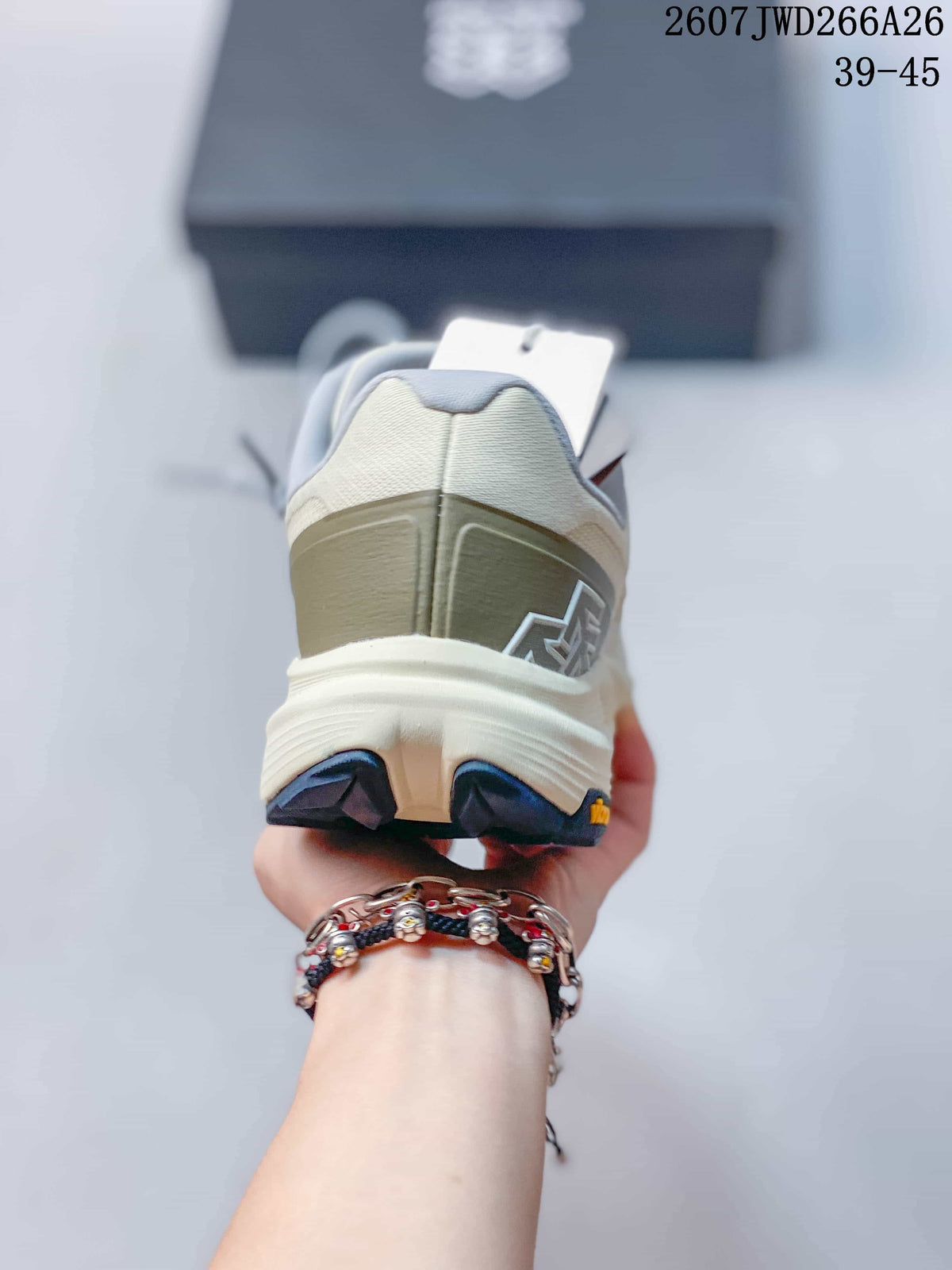 Rear view of an off-white trail running shoe showing the heel structure, navy outsole lugs, and Vibram marking.