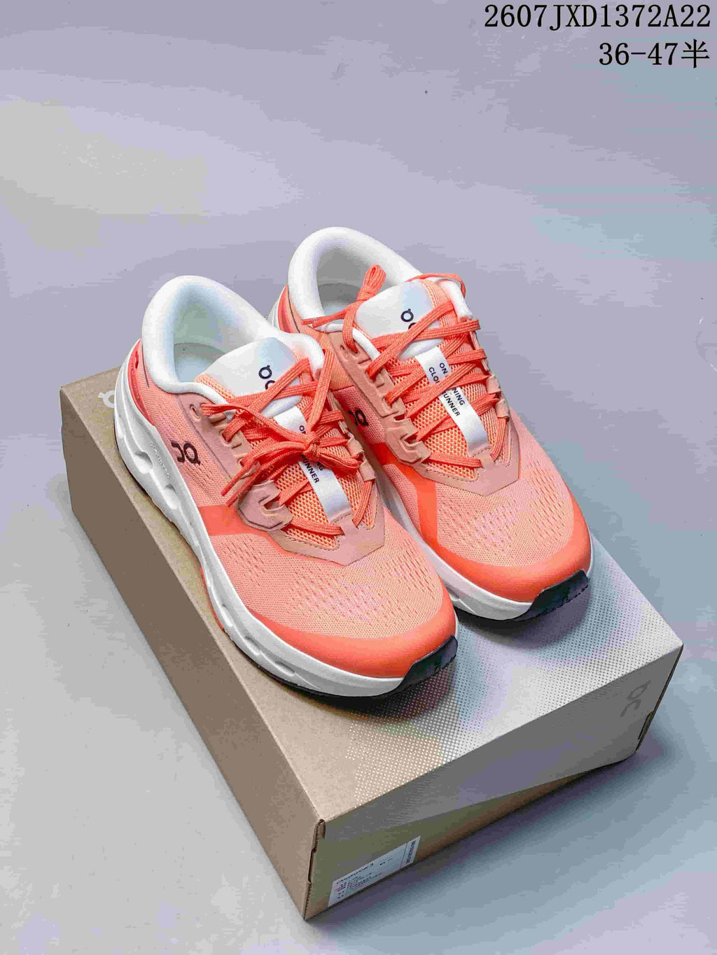 Pair of coral and white On Cloudrunner 3 sneakers displayed on a shoebox, with the style code and advertised EU size range visible above.