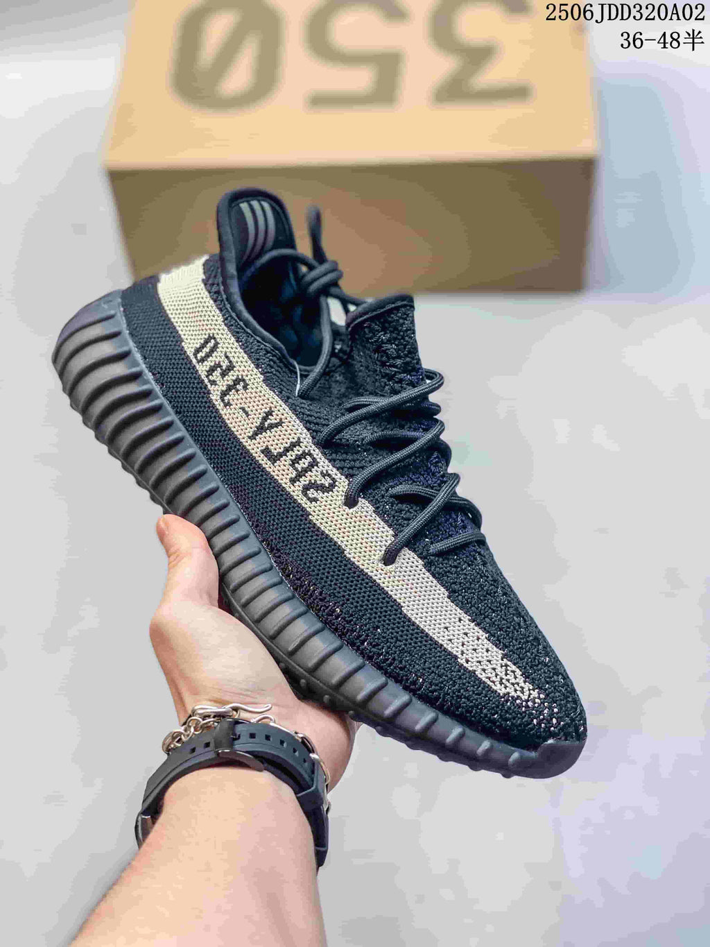 Black knit sneaker with a cream side stripe, black laces, and a ribbed black sole.