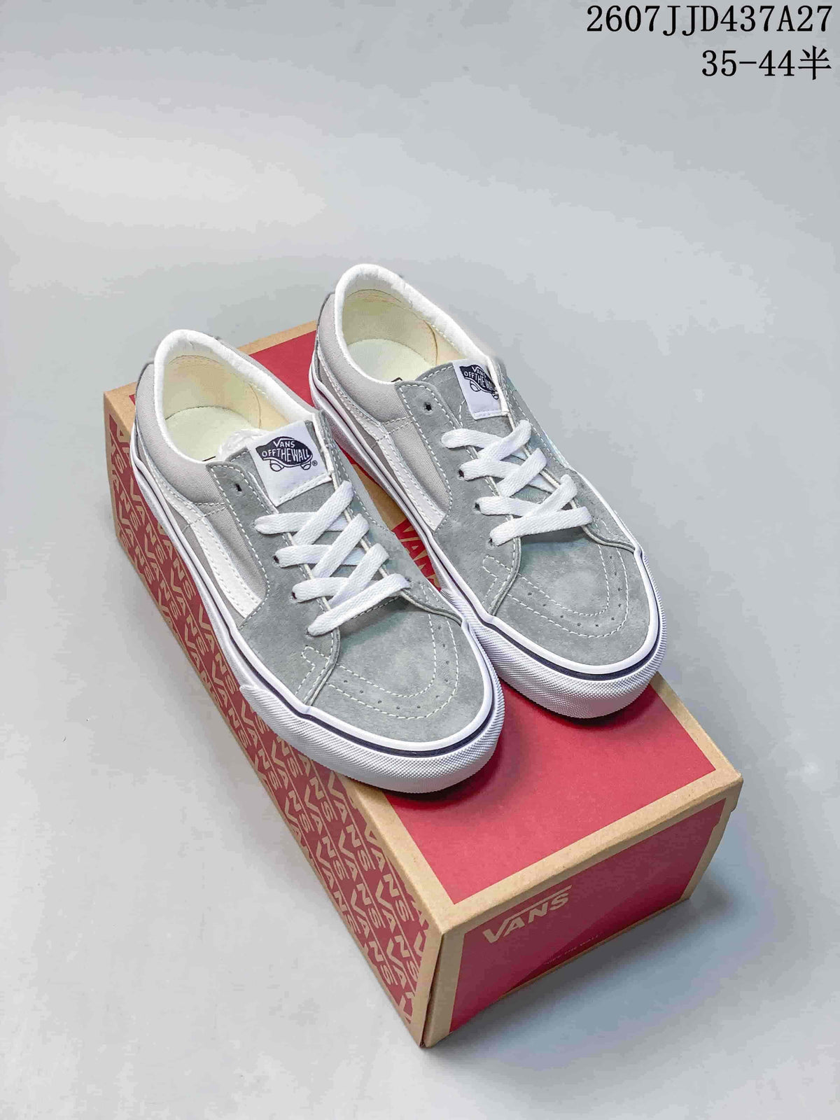 Pair of grey Vans low-top sneakers with white side stripes and laces displayed on a Vans shoebox.