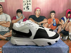 Side view of white and black low-top basketball shoes with a swoosh logo