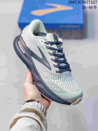 Angled side view showing the grey mesh-like upper, Brooks branding, navy overlays, and thick sole.