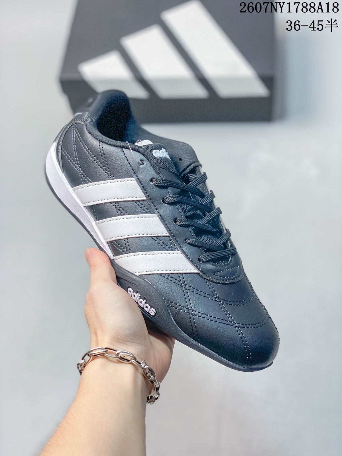 Angled side view showing the navy upper, white stripes, stitching and rubber outsole.