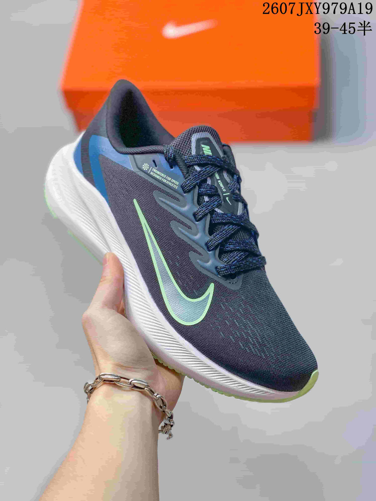 Angled close view of the dark navy and black running sneaker with blue heel detailing, green side logo, and white midsole; overlay shows style code 2607JXY979A19 and size range 39–45.