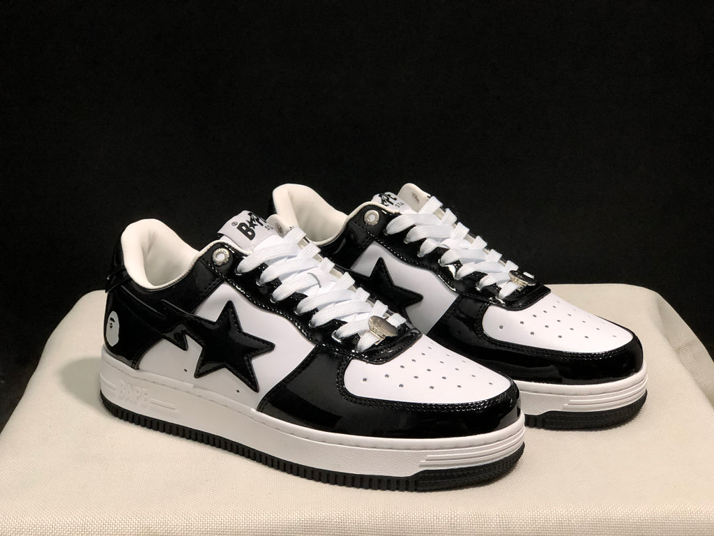 Three-quarter product view showing the black-and-white colorway, star side branding and white midsoles.