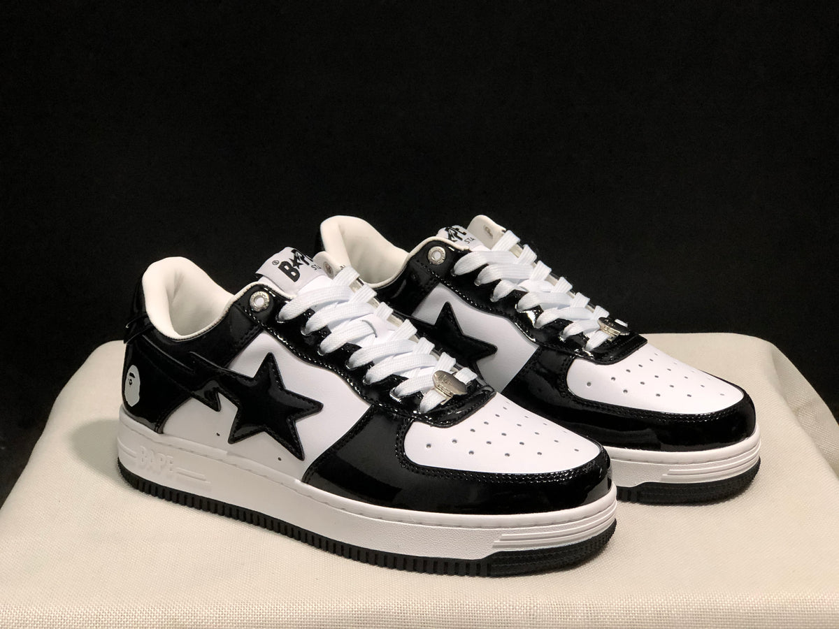 Three-quarter product view showing the black-and-white colorway, star side branding and white midsoles.