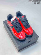Pair of red and black low-top Nike Air Force 1 sneakers displayed on a black shoebox; image text shows style code 2607TGD230A20 and size range 36–45 with half sizes.