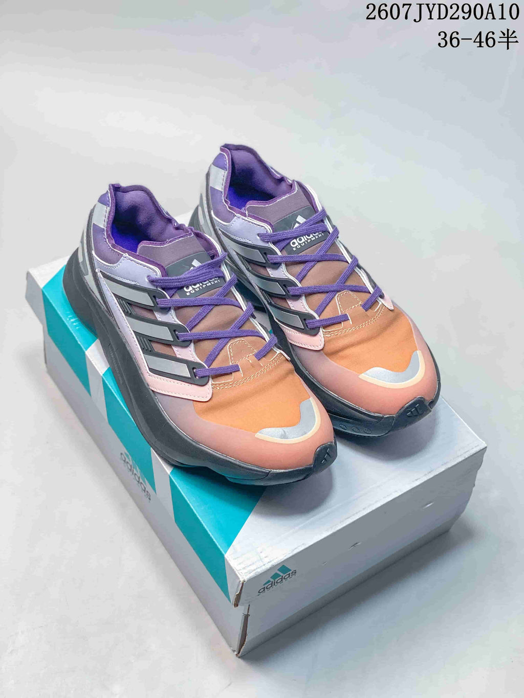 Purple, orange, and gray adidas Equipment Adios Pro sneakers displayed on an adidas shoe box.