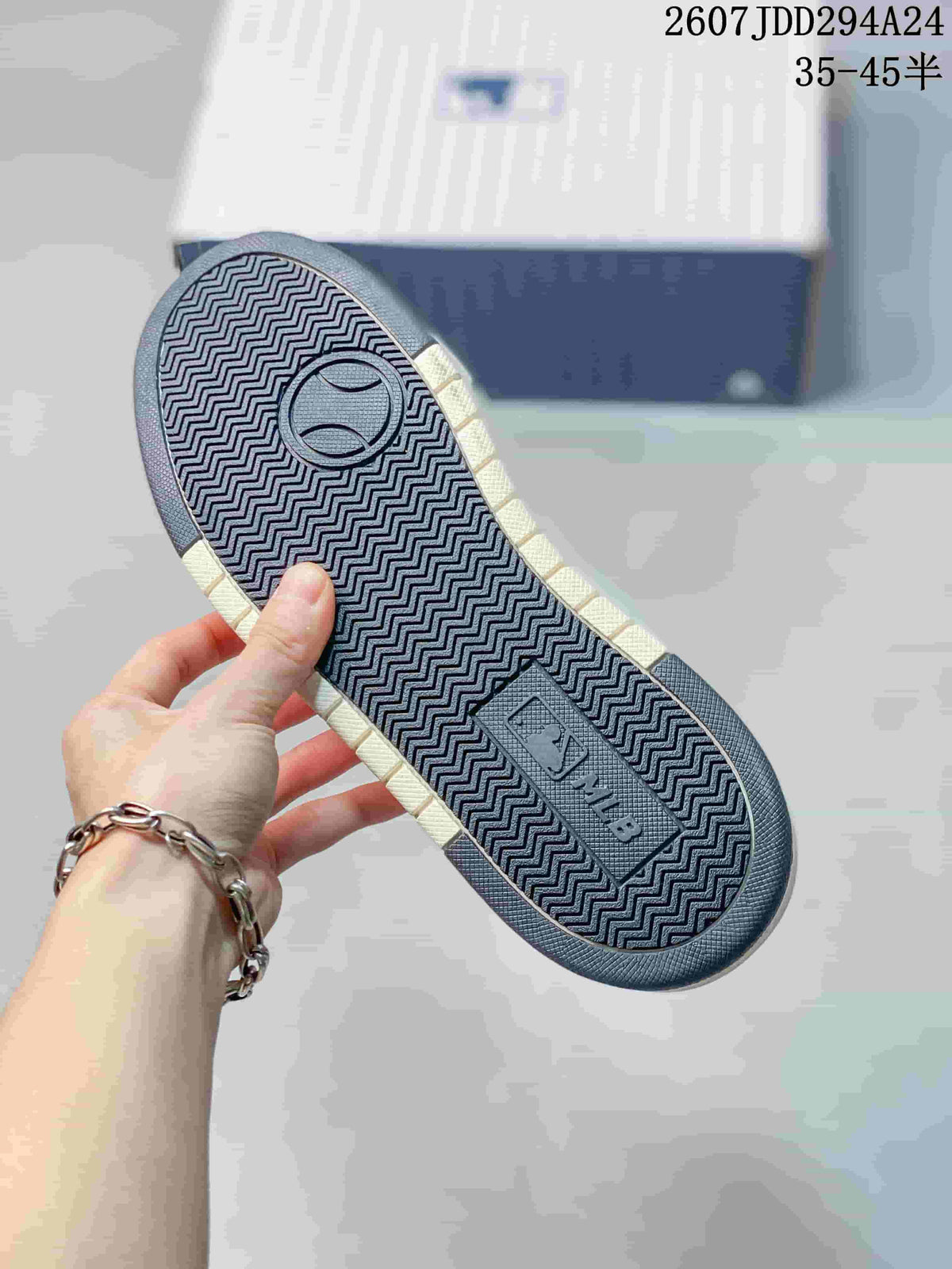 Close view of the sneaker outsole showing a dark zigzag tread pattern and an MLB-branded insert.