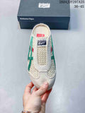 Front view of a cream Onitsuka Tiger Mexico 66 Sabot sneaker with green and red side stripes, shown in front of its branded box.