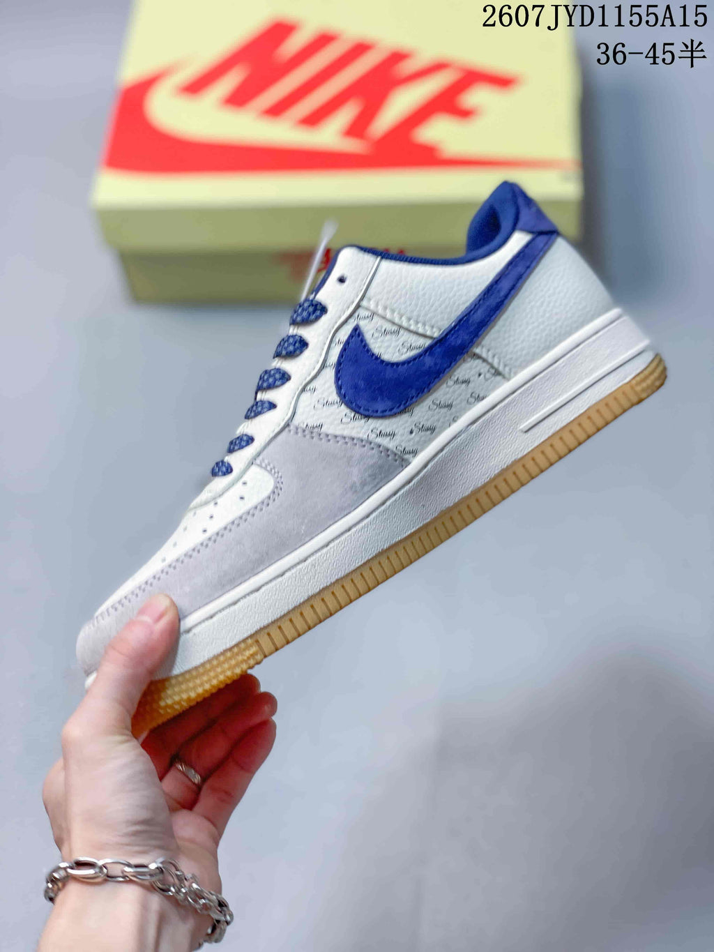 Side view of the sneaker showing the blue Swoosh, patterned side panel, white midsole and gum-colored outsole.