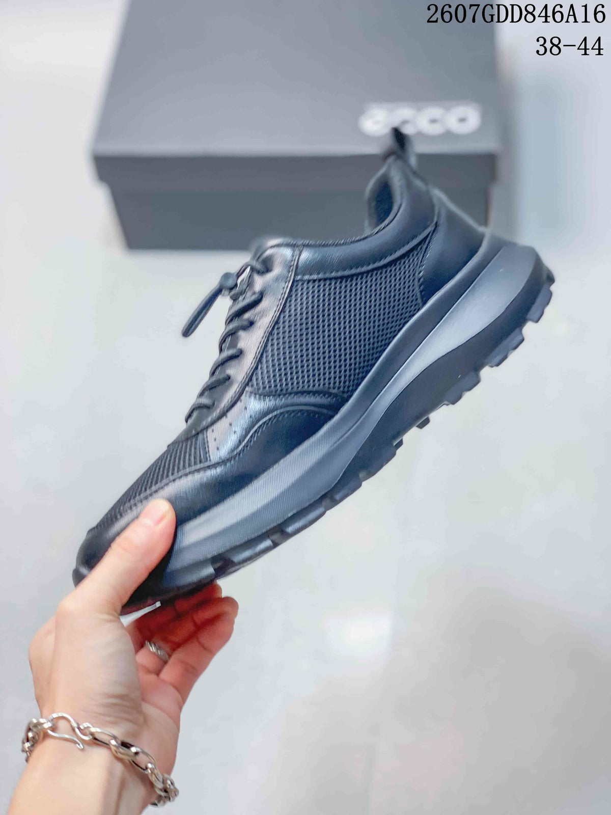 Side profile of the dark sneaker showing mesh side panels, smooth overlays, lace-up construction, and a chunky lugged sole.