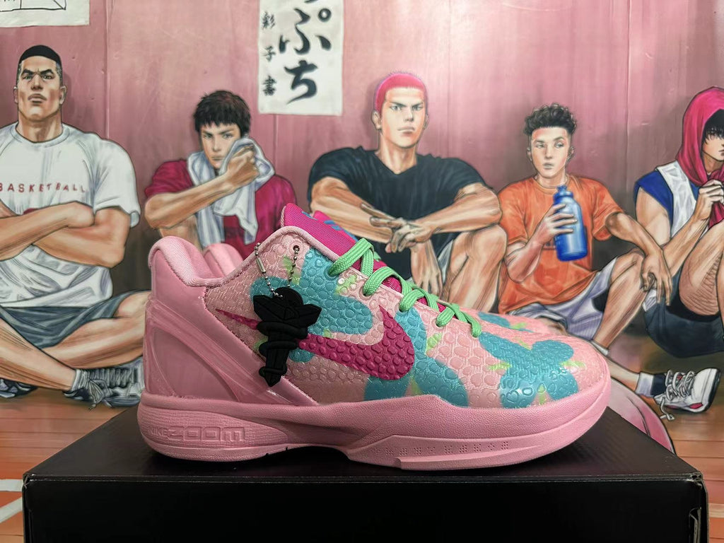 Side view of a pink basketball shoe with teal and magenta patterned panels, a black charm, and visible Nike Zoom branding.