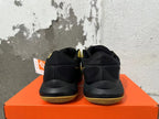 Rear view of black and gold Nike basketball sneakers on an orange box
