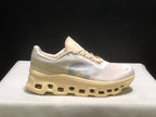 Single side profile of the On Cloudmonster 1 sneaker in a light cream and white colorway.
